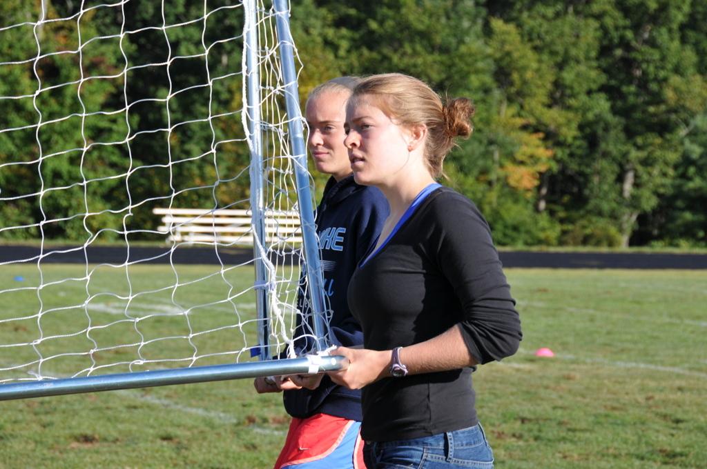 Senior Carlin Pierce helps move goal posts into place.