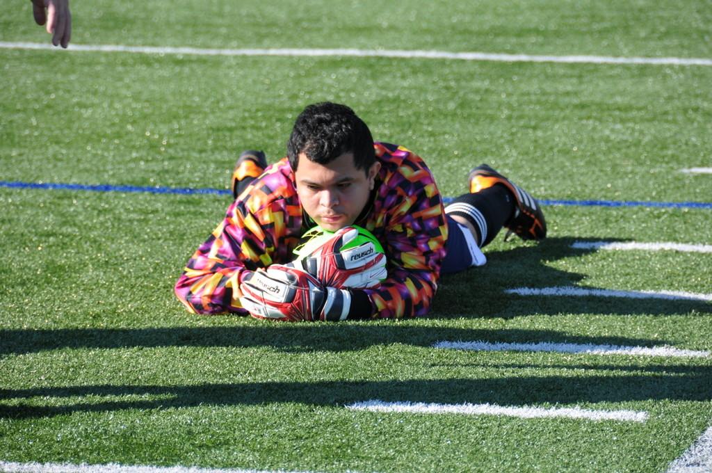 A goalie dives to make a save.