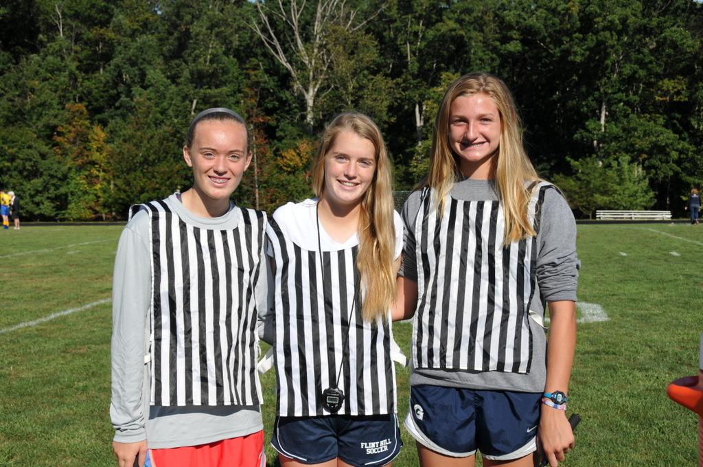 Three referees including Isabel Rice and Madison Crowe, pose for a picture after their game.