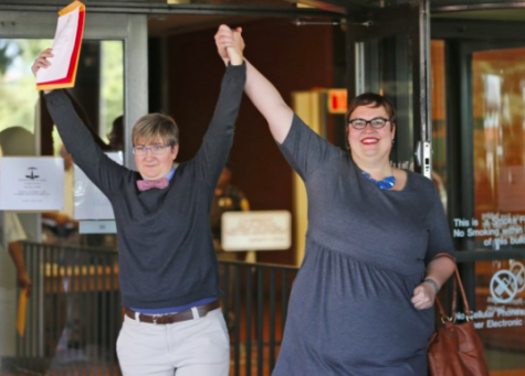 Nicole Pries, left, and Lindsey Oliver hold up their marriage license as they celebrate being one of the first same-sex couples in Virginia to be married outside a Richmond court building. Photo Credit: Steve Helber/AP