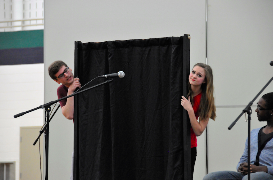 In a tacit scene, two actors undress behind a screen.