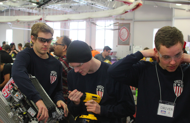 Members of senior team 6652 make last-minute changes to their robot to fit the size restriction and prepare for their first match. (From left:  Eddie Dean, Ben Letowt, and Scott Hamal)
Photo Credit: Michael Snyder