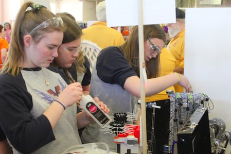Members of Team 6341 respond quickly and efficiently to a mid-competition setback, and succeed in patching the robot up to perfect working condition. (From left: junior Hailey Scherer, sophomore Giana Fiore, and junior Cailin Mazan.) Photo credit: Michael Snyder