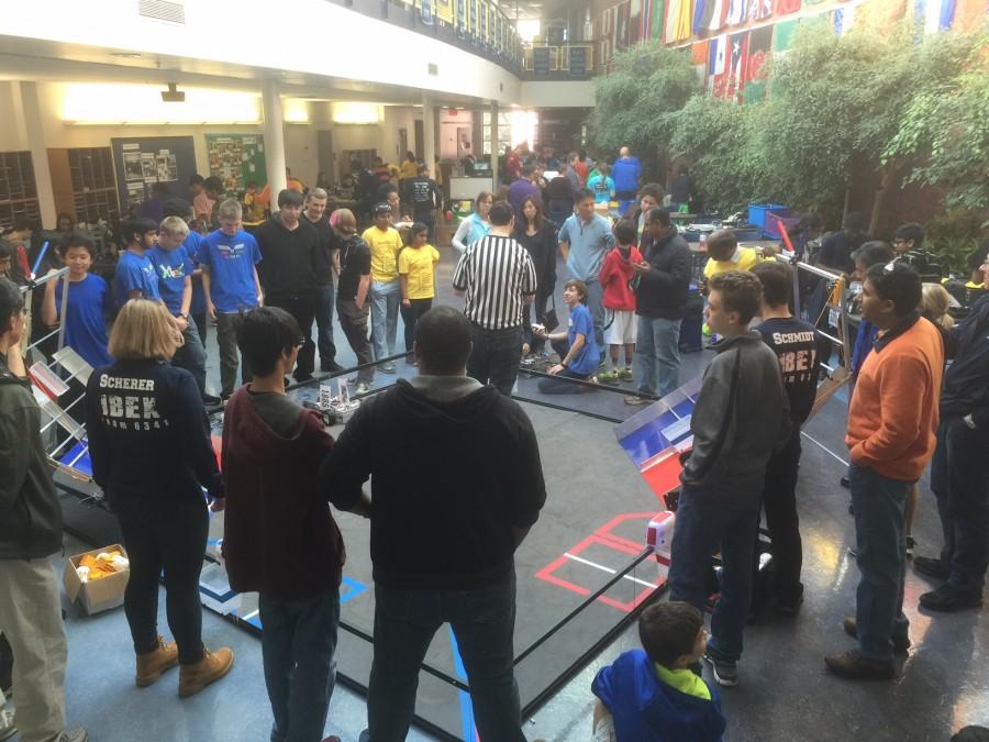 Robotics students gather around the field in the Commons to test out their robots. 
