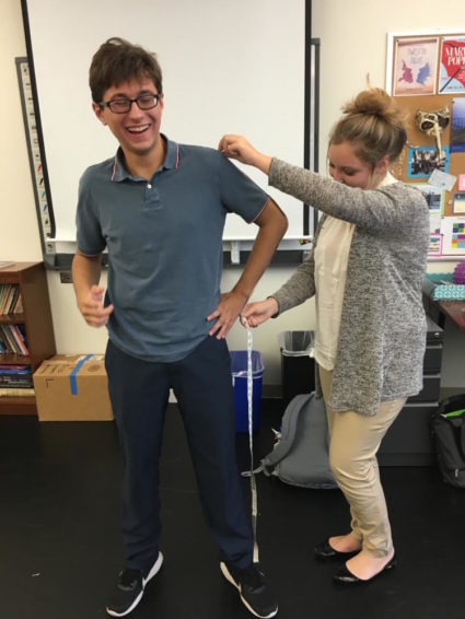 Taking measurements of the actors to order costumes.