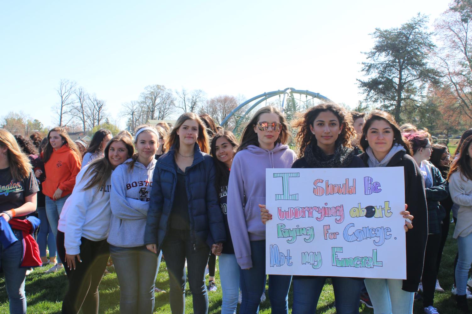 Leyla Ebrahimi holds a sign she made, standing beside her peers.